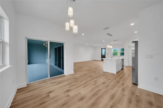 9333 Hialeah Ter, Port Charlotte, FL 33981 - unfurnished living room featuring a chandelier, light wood finished floors, recessed lighting, and a barn door