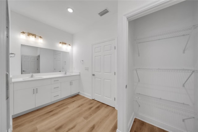 9333 Hialeah Ter, Port Charlotte, FL 33981 - bathroom featuring double vanity, wood finished floors, recessed lighting, and a walk in closet