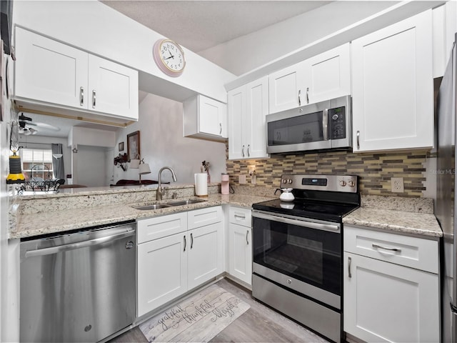 5421 Lake Margaret Dr Unit 178, Orlando, FL 32812 - kitchen with appliances with stainless steel finishes, white cabinets, tasteful backsplash, and light wood-style flooring