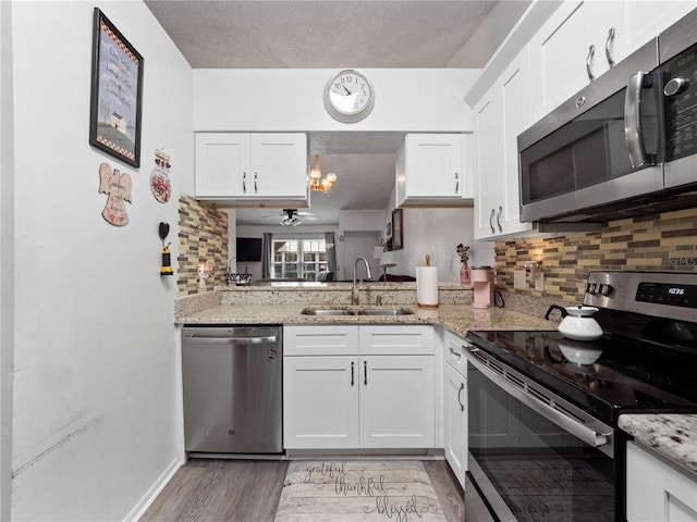 5421 Lake Margaret Dr Unit 178, Orlando, FL 32812 - kitchen with stainless steel appliances, light wood-type flooring, white cabinetry, and backsplash