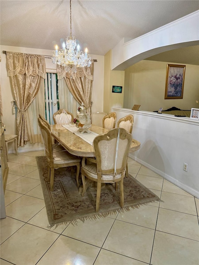 1945 Torrey Dr, Orlando, FL 32818 - dining area featuring light tile patterned floors, a chandelier, arched walkways, and a textured ceiling