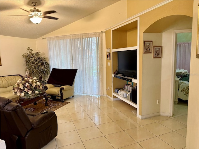 1945 Torrey Dr, Orlando, FL 32818 - living area featuring arched walkways, ceiling fan, light tile patterned floors, lofted ceiling, and a textured ceiling