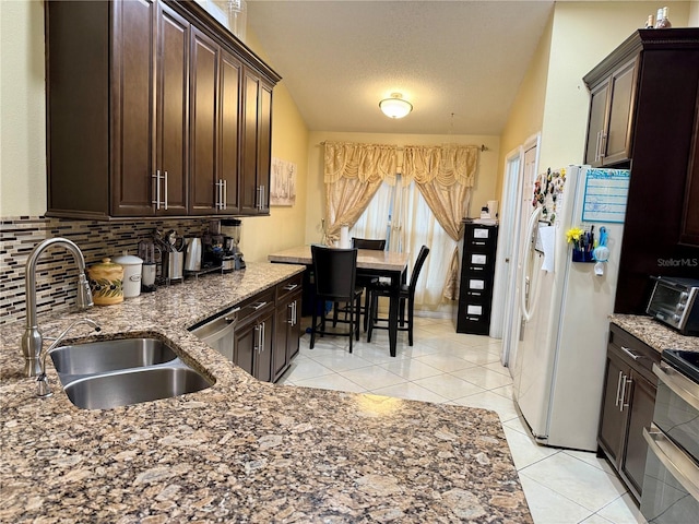 1945 Torrey Dr, Orlando, FL 32818 - kitchen featuring appliances with stainless steel finishes, tasteful backsplash, dark brown cabinets, and a textured ceiling