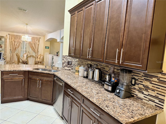 1945 Torrey Dr, Orlando, FL 32818 - kitchen with dishwasher, tasteful backsplash, a chandelier, arched walkways, and light stone countertops