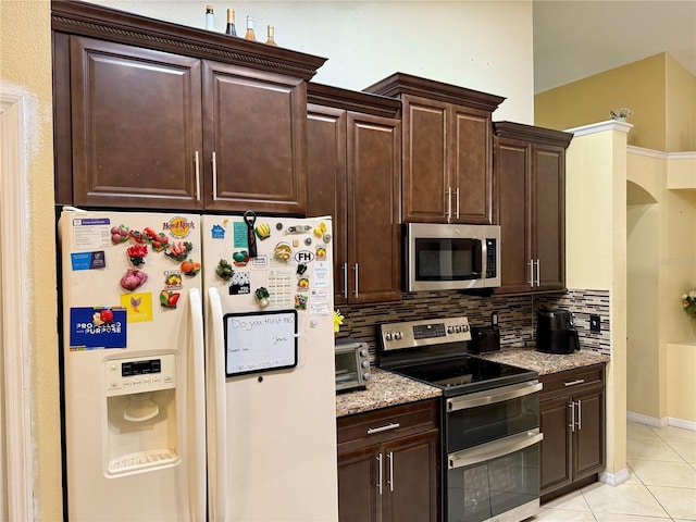 1945 Torrey Dr, Orlando, FL 32818 - kitchen featuring appliances with stainless steel finishes, backsplash, light tile patterned floors, and dark brown cabinetry