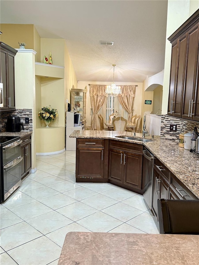 1945 Torrey Dr, Orlando, FL 32818 - kitchen featuring stainless steel appliances, backsplash, dark brown cabinets, arched walkways, and light tile patterned floors