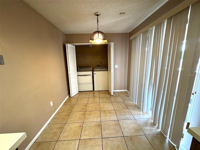 5359 Vineland Rd Unit S, Orlando, FL 32811 - unfurnished dining area with washing machine and dryer, light tile patterned flooring, and a textured ceiling