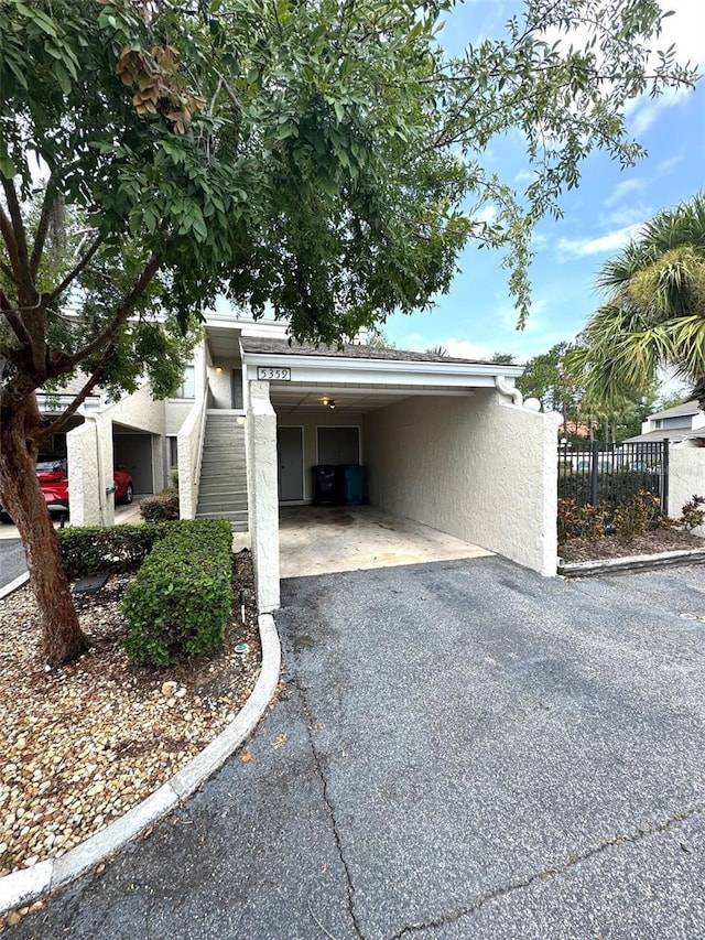 5359 Vineland Rd Unit S, Orlando, FL 32811 - view of side of property featuring asphalt driveway, a carport, and stucco siding