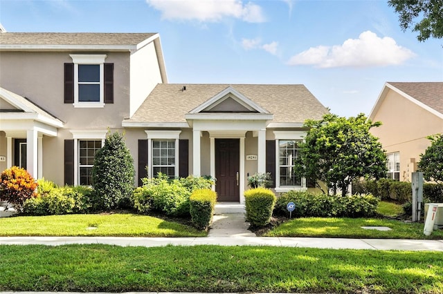 14241 Confetti Dr, Windermere, FL 34786 - view of front facade featuring stucco siding, a front lawn, and roof with shingles