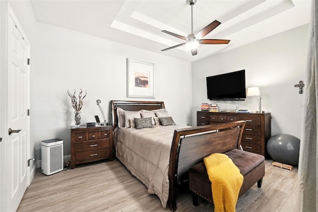 14241 Confetti Dr, Windermere, FL 34786 - bedroom with light wood-style floors, a tray ceiling, and ceiling fan