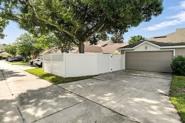 14241 Confetti Dr, Windermere, FL 34786 - view of side of property with driveway, stucco siding, a residential view, and an attached garage