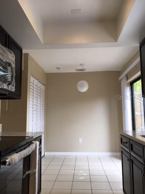 3370 Cedar Springs Pl Unit 156, Winter Park, FL 32792 - kitchen featuring a tray ceiling, electric stove, decorative light fixtures, light stone counters, and dark cabinets
