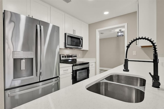 1838 Windmill Dr, Orlando, FL 32818 - kitchen with appliances with stainless steel finishes, white cabinetry, light stone countertops, and recessed lighting