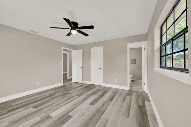 1838 Windmill Dr, Orlando, FL 32818 - unfurnished bedroom featuring wood finished floors, connected bathroom, and a ceiling fan