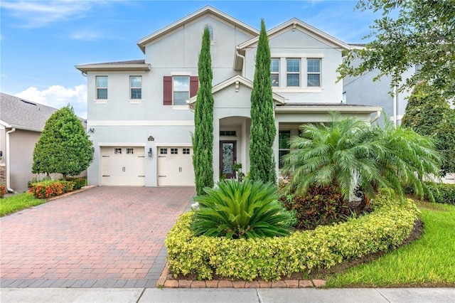 9518 Bolero Rd, Winter Garden, FL 34787 - view of front facade with an attached garage, stucco siding, and decorative driveway