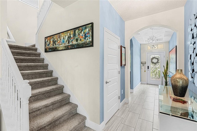 9518 Bolero Rd, Winter Garden, FL 34787 - foyer with arched walkways, a chandelier, and stairs