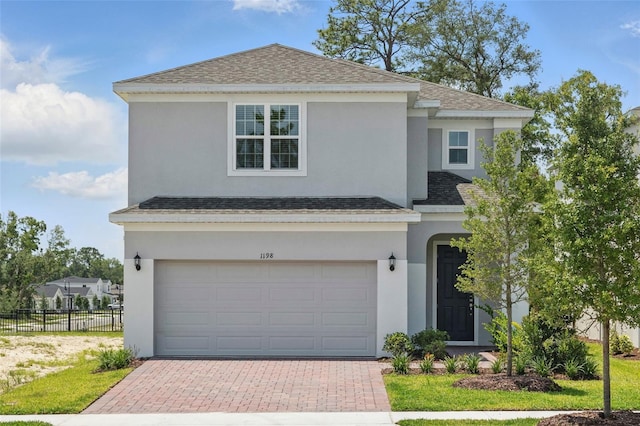 1198 Happy Forest Loop, Deland, FL 32720 - view of front of house featuring an attached garage, decorative driveway, roof with shingles, and stucco siding