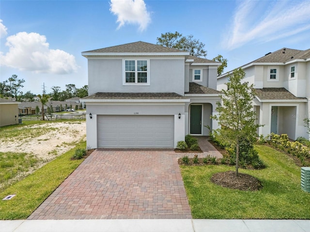 1198 Happy Forest Loop, Deland, FL 32720 - traditional-style house with a garage, decorative driveway, stucco siding, a front lawn, and roof with shingles
