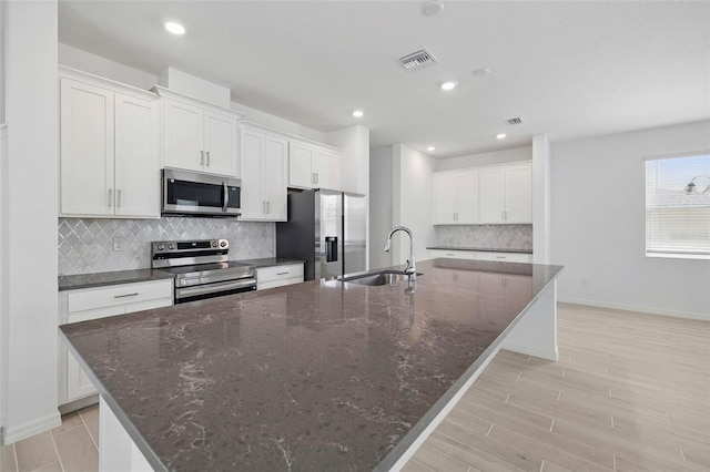 1198 Happy Forest Loop, Deland, FL 32720 - kitchen with stainless steel appliances, a spacious island, decorative backsplash, white cabinets, and recessed lighting