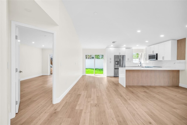 13412 NW 5th Ct, Plantation, FL 33325 - kitchen featuring stainless steel appliances, light wood-type flooring, open floor plan, light countertops, and a peninsula