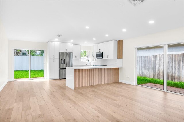 13412 NW 5th Ct, Plantation, FL 33325 - kitchen with appliances with stainless steel finishes, a peninsula, light wood-type flooring, and recessed lighting