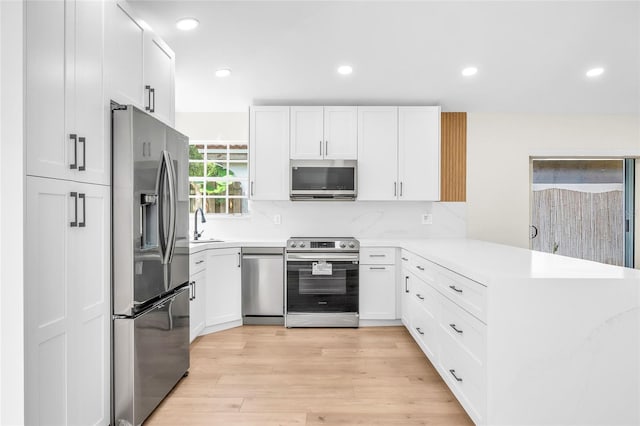 13412 NW 5th Ct, Plantation, FL 33325 - kitchen featuring stainless steel appliances, a peninsula, light countertops, white cabinetry, and recessed lighting