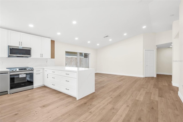 13412 NW 5th Ct, Plantation, FL 33325 - kitchen featuring stainless steel appliances, a peninsula, light countertops, white cabinets, and light wood finished floors