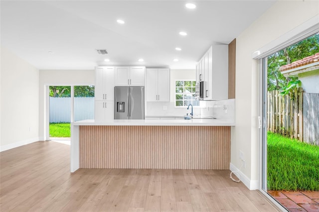 13412 NW 5th Ct, Plantation, FL 33325 - kitchen with stainless steel fridge, a peninsula, light countertops, light wood-style flooring, and recessed lighting
