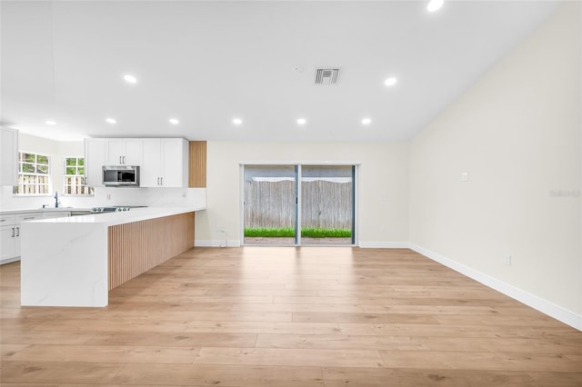 13412 NW 5th Ct, Plantation, FL 33325 - kitchen featuring stainless steel microwave, a peninsula, recessed lighting, light wood finished floors, and black electric stovetop