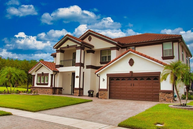 2851 Swoop Cir, Kissimmee, FL 34741 - mediterranean / spanish house featuring a balcony, a front lawn, stone siding, decorative driveway, and stucco siding
