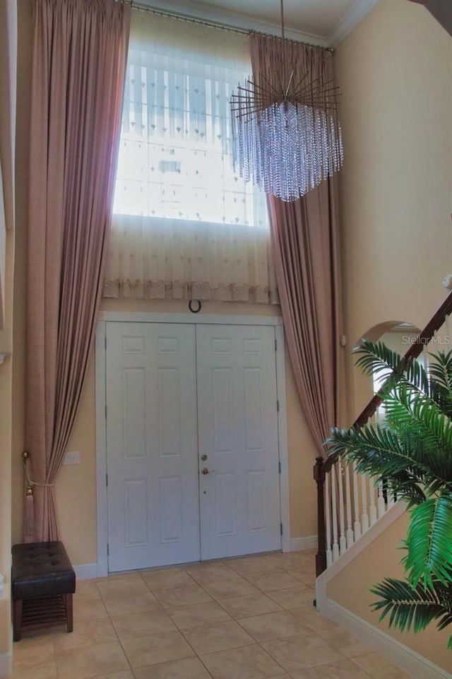 2851 Swoop Cir, Kissimmee, FL 34741 - entryway featuring light tile patterned flooring, ornamental molding, and a chandelier
