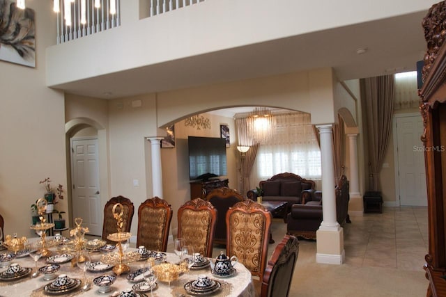 2851 Swoop Cir, Kissimmee, FL 34741 - carpeted dining area featuring arched walkways, ornate columns, tile patterned flooring, and a towering ceiling