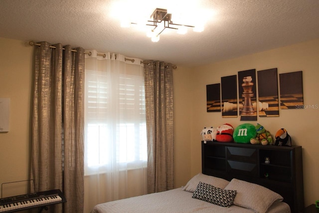 2851 Swoop Cir, Kissimmee, FL 34741 - bedroom featuring a chandelier and a textured ceiling