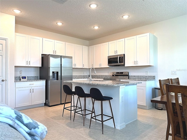 764 Richmond Estate Ave, Haines City, FL 33844 - kitchen featuring stainless steel appliances, a center island with sink, a breakfast bar area, stone countertops, and recessed lighting