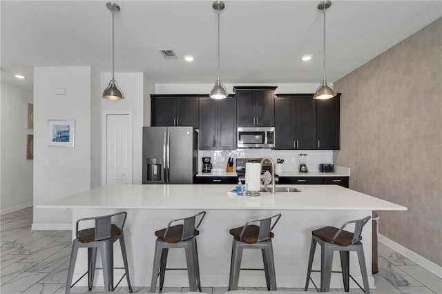 9005 Stinger Dr, Davenport, FL 33896 - kitchen with appliances with stainless steel finishes, light marble finish floors, light countertops, a breakfast bar area, and recessed lighting