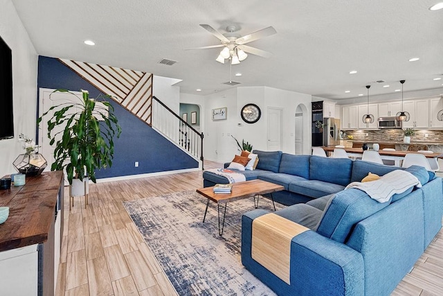 1210 Woods Landing Dr, Minneola, FL 34715 - living room featuring arched walkways, ceiling fan, light wood finished floors, stairway, and recessed lighting