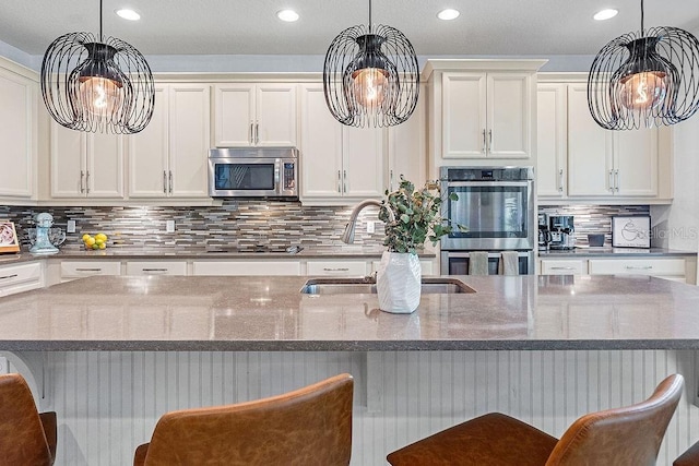 1210 Woods Landing Dr, Minneola, FL 34715 - kitchen with stainless steel appliances, a chandelier, recessed lighting, decorative backsplash, and white cabinets