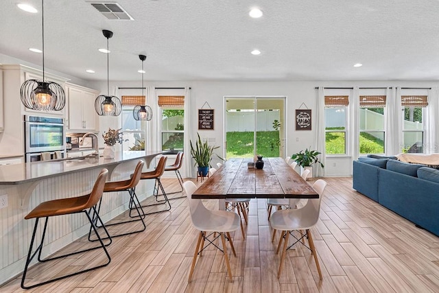 1210 Woods Landing Dr, Minneola, FL 34715 - dining space with wood tiled floors, recessed lighting, and a textured ceiling