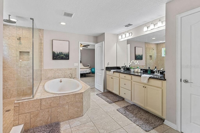 1210 Woods Landing Dr, Minneola, FL 34715 - bathroom featuring a tile shower, double vanity, tile patterned floors, a bath, and a textured ceiling