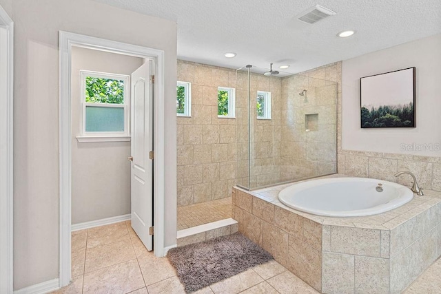 1210 Woods Landing Dr, Minneola, FL 34715 - bathroom featuring a garden tub, walk in shower, plenty of natural light, tile patterned floors, and a textured ceiling