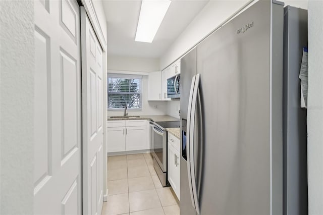 2200 S Palmetto Ave Unit B050, South Daytona, FL 32119 - kitchen featuring stainless steel appliances, white cabinetry, light tile patterned floors, and light stone counters