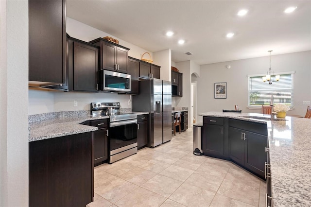 416 Riders Loop, Auburndale, FL 33823 - kitchen featuring stainless steel appliances, arched walkways, recessed lighting, light tile patterned floors, and a chandelier