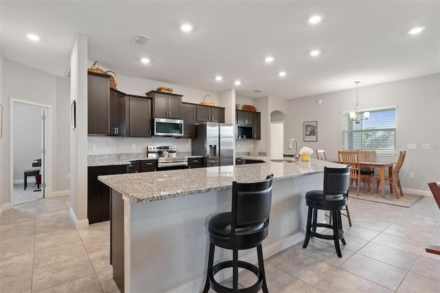 416 Riders Loop, Auburndale, FL 33823 - kitchen featuring stainless steel appliances, a large island, dark brown cabinets, recessed lighting, and a kitchen bar