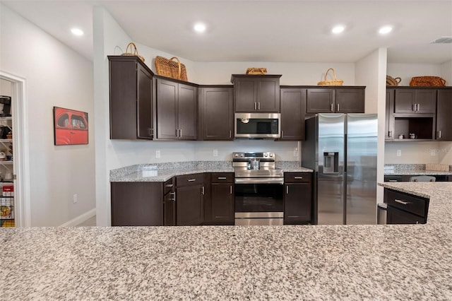 416 Riders Loop, Auburndale, FL 33823 - kitchen with stainless steel appliances, dark brown cabinets, light stone counters, and recessed lighting