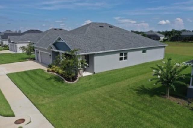 416 Riders Loop, Auburndale, FL 33823 - view of side of property featuring driveway, an attached garage, and a yard