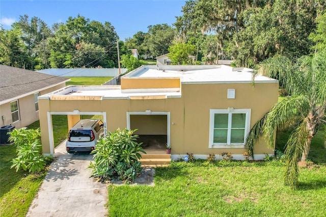 1505 E Elm Rd, Lakeland, FL 33801 - back of property featuring concrete driveway, stucco siding, a lawn, and a carport
