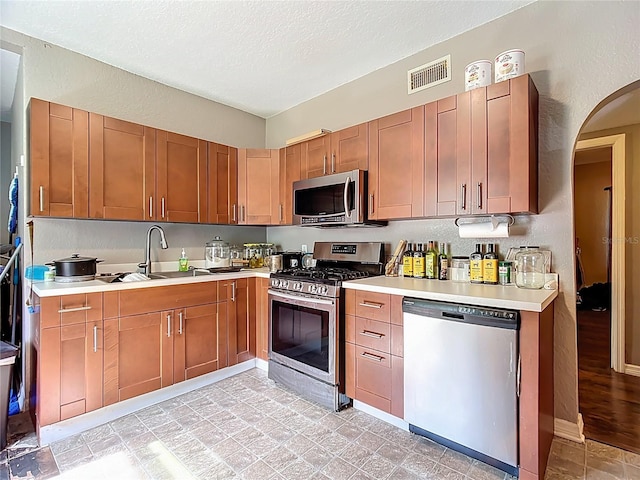 1505 E Elm Rd, Lakeland, FL 33801 - kitchen with appliances with stainless steel finishes, light countertops, arched walkways, and a textured ceiling