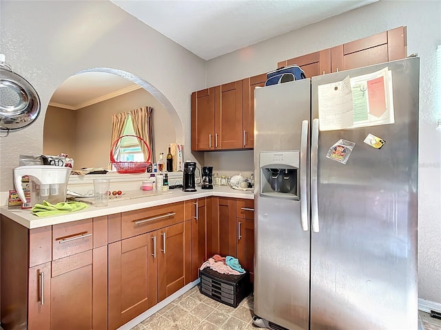 1505 E Elm Rd, Lakeland, FL 33801 - kitchen with stainless steel refrigerator with ice dispenser, ornamental molding, light countertops, arched walkways, and brown cabinets