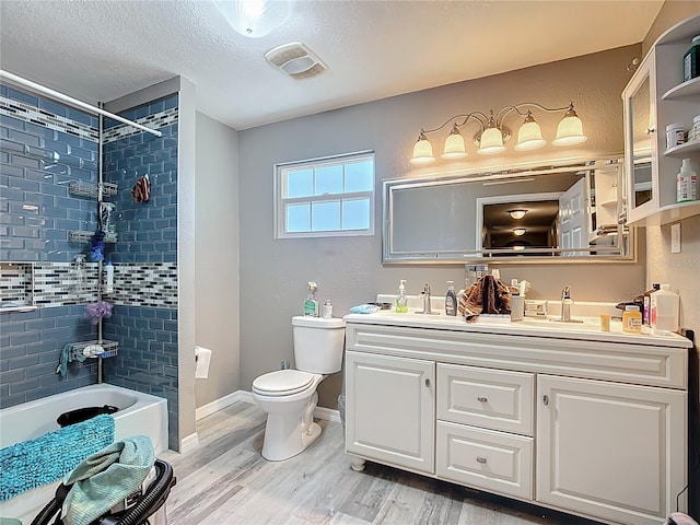 1505 E Elm Rd, Lakeland, FL 33801 - bathroom featuring double vanity, wood finished floors,  shower combination, and a textured ceiling
