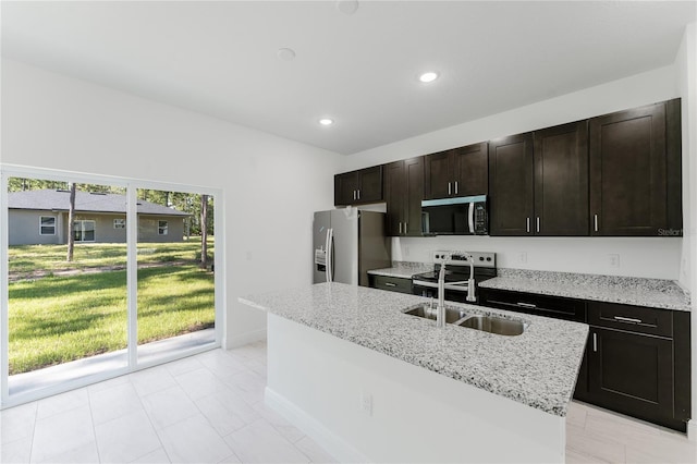 627 W Glenhaven Dr, Citrus Springs, FL 34434 - kitchen featuring stainless steel appliances, recessed lighting, light stone counters, a center island with sink, and dark brown cabinets